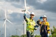 © BESTIMAGE - Teamwork engineers coaching wind turbine power generator sustainability performance brainstorming together at Renewable Energy Plant Male and female engineer with equipment working at windmill