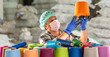 © BESTIMAGE - Textile factory male worker in mask hairnet and gloves handling and checking colorful yarn spool for quality control Industrial textile inspection with focus in warehouse