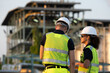 © BESTIMAGE - Industrial workers team discussing petroleum engineering in oil refinery project collaboration at fuel industry Rear view of male worker talking with female hold laptop outside construction site