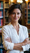 © Alive - Woman stands in library with books in background wearing a white shirt