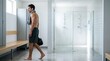 © SashaMagic - Fit man with towel walks through modern gym locker room towards showers, copy space for ads