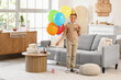 © Pixel-Shot - Cute little African-American boy in party hat with whistle and air balloons celebrating birthday in living room