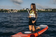 © Roman - Woman enjoying stand up paddleboarding on lake water