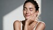 © VisionCrafter - Close-up portrait of a serene young woman resting her chin on her hand and smiling with closed eyes in soft natural sunlight