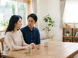© Anoconone - 深刻な表情で話し合いながら涙を流す夫婦と悲しむ女性