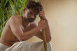 © IndiaPix - Portrait of  rural farmer holding hoe sitting against crops