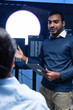 © SAT65 - Programmer team collaboration, working on coding task, reviewing code while Male Programmer presenting code in the screen in tech office.