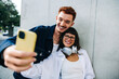 © Julia - Happy couple taking a selfie together with friends