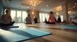 © Justlight - Medium shot of a yoga workshop in progress with mats in sharp focus and participants softly blurred showcasing the serene and adaptable room setup.