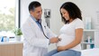 © ArtSync Studio - Friendly Doctor Using Stethoscope on the Growing Belly of a Smiling Pregnant Patient