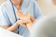 © KMPZZZ - Close up of a physical therapist massaging and examining a patient hand for wrist and trigger fingers rehabilitation, carpal tunnel syndrome and office syndrome occupational therapy medical concept.