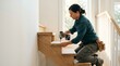 © SashaMagic - Carpenter installing wooden stair treads with a power drill in a bright, modern home interior, emphasizing craftsmanship and construction.