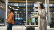 © DC Studio - Woman traveler carries takeaway coffee and pulls trolley luggage through a bus terminal departure hall, enjoying a refreshment before continuing an intercity coach journey with personal baggage.