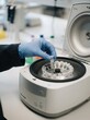 © SimpleDesignStudio - Scientist using laboratory centrifuge with microcentrifuge tubes for medical research and testing