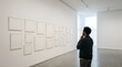 © Miles - Man looking at blank white frames on gallery wall in a bright museum