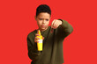 © Pixel-Shot - African-American boy with cockroach and insect repellent on red background