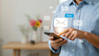 © Forida - Man using smartphone to read and check new email messages with digital notification icons