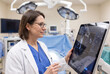 © Faizan - A female surgeon reviews AI-assisted surgical planning before entering an operating room. Surgical equipment in the background and a calm, confident expression emphasize precision, preparation,.