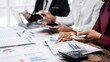© Freedomz - Three people are sitting at a table with papers and a calculator