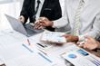© Freedomz - Three men are sitting at a table with a laptop and papers