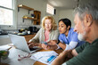 © Marko Geber - Caregiver helping senior couple with online banking at home