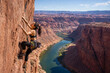 © Fiandesain - Determined woman fearlessly ascends a majestic sandstone cliff face, showcasing her strength and agility during an exhilarating outdoor rock climbing adventure above a winding river canyon