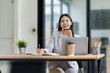 © David - Asian businesswoman making a phone call on speaker, dictating notes and multitasking during work