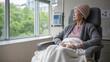 © AlenaSi - Cancer patient receiving chemotherapy treatment in hospital with intravenous infusion. The patient, an elderly woman, reflects while gazing out the window, draped in a blanket.