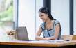 © David - Young asian woman smiling, working on laptop at desk. Remote work, online business, and happy professional concept