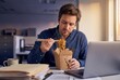 © spyrakot - Businessman eating takeout noodles at desk during lunch break in office