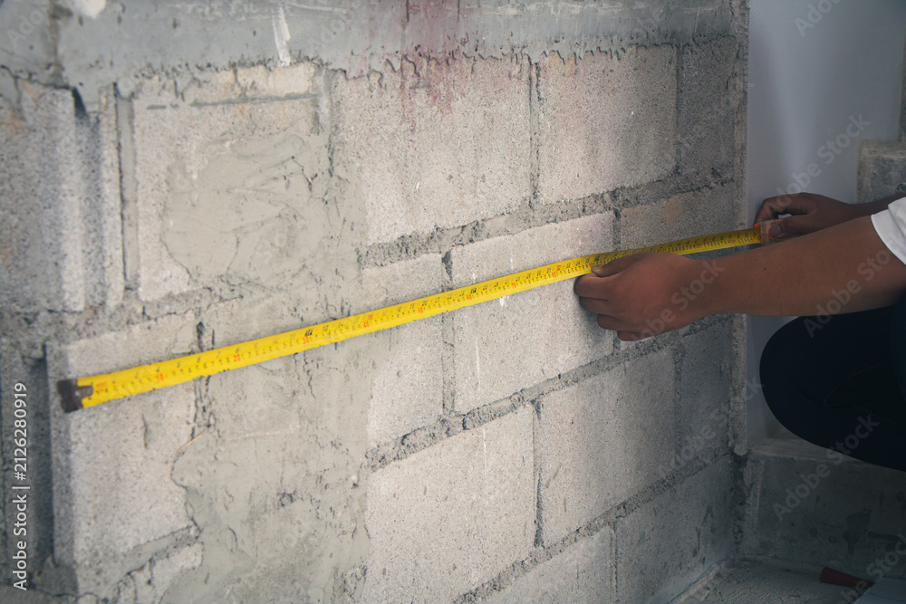 Construction inspector measuring structural dimensions with a tape ...