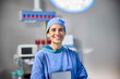 © Guille Faingold/Stocksy - A healthcare professional smiles confidently in surgical attire