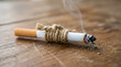© Hajera - Burning cigarette resting on wooden surface