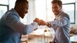 © Surachetsh - Fist bump and punch teamwork from business partnership celebrate shared success as two professionals mark an achievement with a confident gesture in the office.