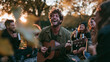 © BlackBridge Media - Happy Man Playing Acoustic Guitar for Friends in Park at Sunset