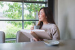 © Farknot Architect - Portrait image of a woman reading a book and drinking coffee