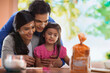 © IndiaPix - Happy parents with daughter baking cookies in kitchen