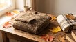 © warizshake - Knitted sweater and autumn leaves on a rustic wooden table