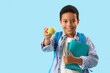 © Pixel-Shot - Little African-American schoolboy with books and apple on light blue background