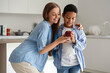© Pixel-Shot - Mother giving apple to little schoolboy in kitchen