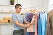 © Kawee - Caucasian young woman looking to product of clothes in shopping mall.