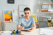 © Kawee - Caucasian beautiful young woman drawing artwork at cozy home studio.