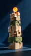 © Angs - Vertical photo of a complex tower made of wooden, cardboard, and glass blocks topped with a glowing orange sphere. Physical metaphor for a fragile technology stack