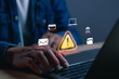 © PB Studio Photo - Businessman monitoring system security warning on laptop, highlighting cyberattack detection, hacking alert, ransomware protection, data security, threat monitoring and cybersecurity defense