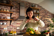 © Davor - Woman photographing fresh produce in home kitchen