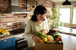 © Davor - Woman unpacking fresh produce delivery at home kitchen
