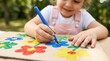 © Amonrat - Kid creates colorful art with a blue marker at a kindergarten or summer camp.