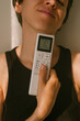 © Duet Postscriptum/Stocksy - Person With Remote Control for AC in Warm Light
