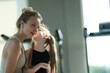 © ultramansk - Young mother and her little daughter lift and swing the laughing girl playfully by the treadmills after a family workout in the gym. Real people enjoying everyday life moments
