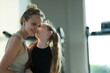 © ultramansk - Young mother and her little daughter play together, mom lifting the giggling child high after a family workout in the gym, candid real moment. Happy family lifestyle and wellbeing concept